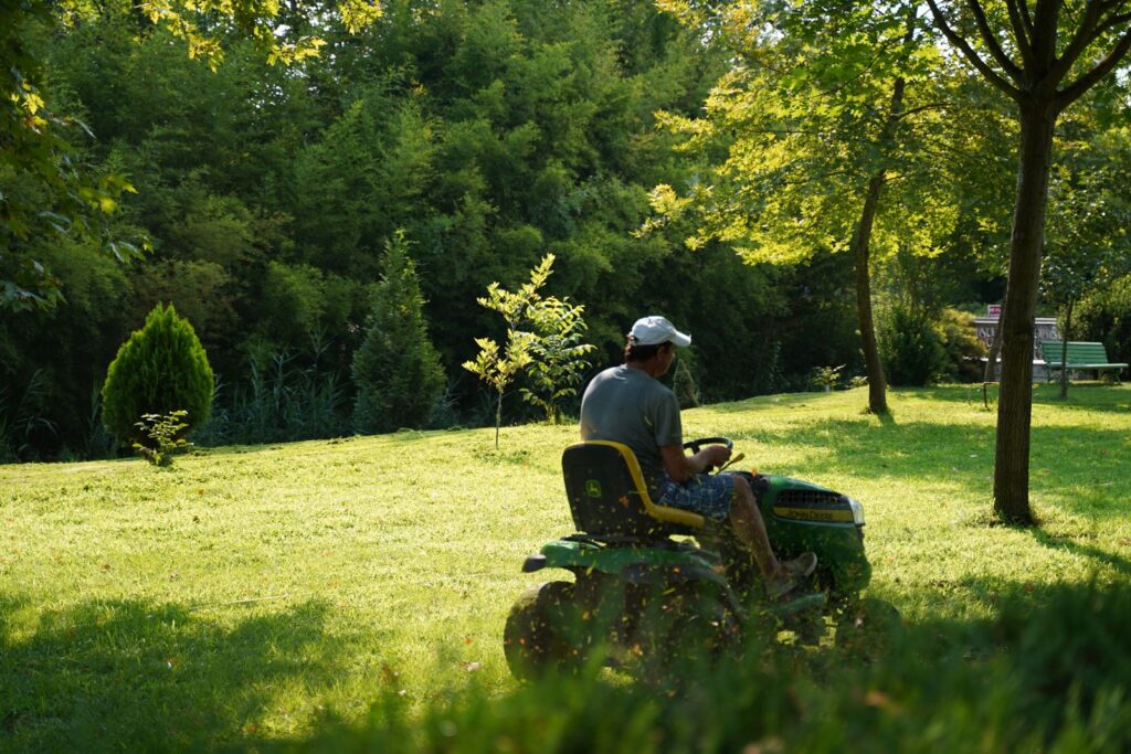 Riding mower cutting a shaded lawn